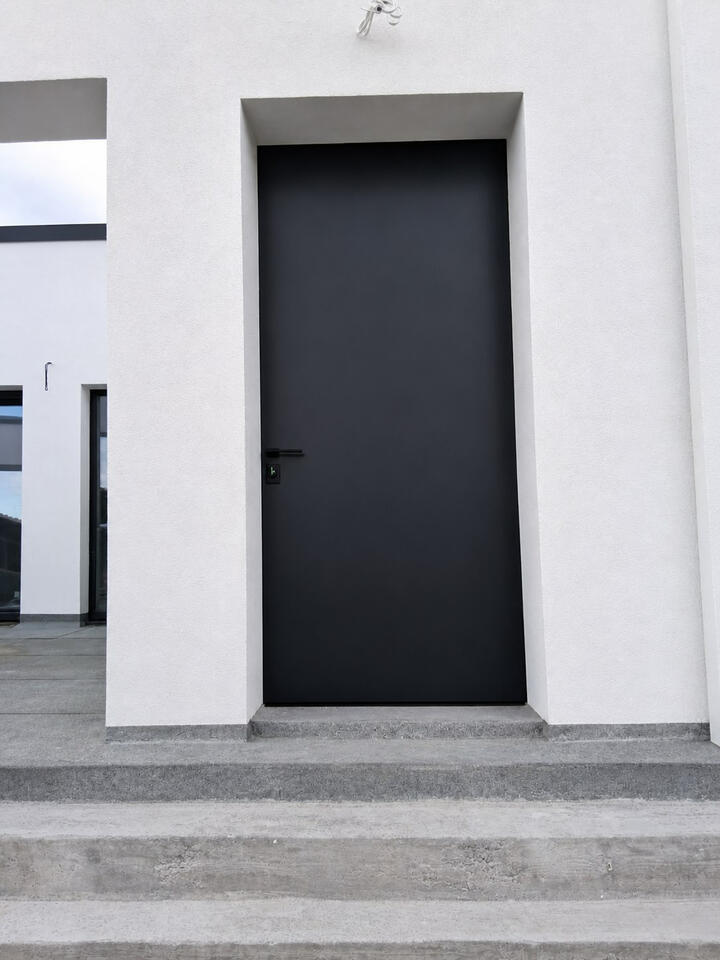Alternative materials Dark exterior door manufactured with a project-specific alternative material