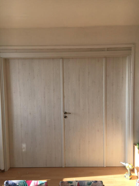 Made-to-measure multi-panel door system for an extra-wide interior opening